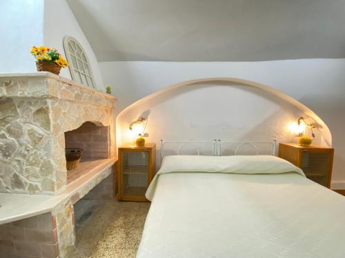 a bedroom with a stone fireplace and a bed at Lo Scoglio Bianco in Gallipoli