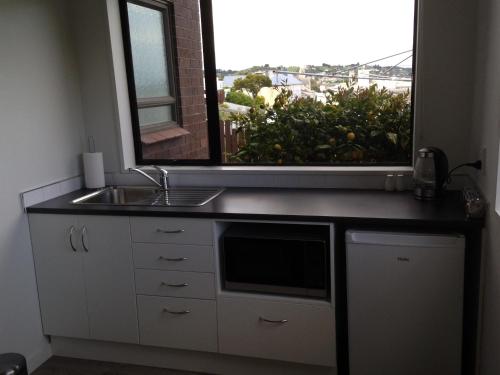 a kitchen with a sink and a large window at Affordable On Arun in Oamaru