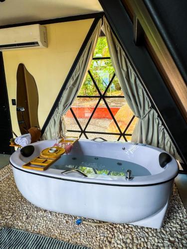 a bath tub in a room with a window at Cabana Quintal in Aquidauana