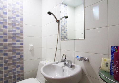 a bathroom with a sink and a toilet and a mirror at Dorandoran Guesthouse in Gyeongju