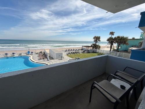 a balcony with a view of a pool and the beach at Driftwood Beach Motel in Ormond Beach