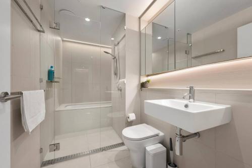 a bathroom with a sink and a toilet and a shower at 39th floor luxurious spacious apartment in Melbourne
