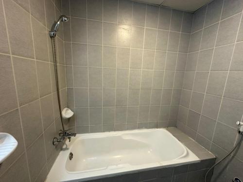 a bathroom with a tub and a sink at Your Comfort Starts Here in Ras al Khaimah