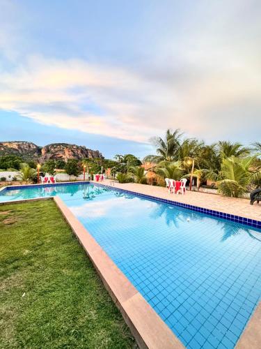 a swimming pool at a resort with mountains in the background at Pousada e restaurante trilha da capivara in Coronel José Diaz