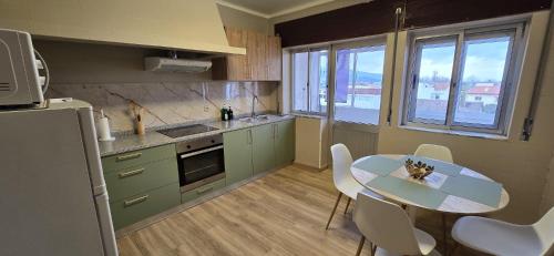 a kitchen with a table and a table and chairs at Apartamento Vila Melgaço in Melgaço