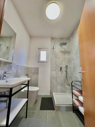a bathroom with a tub and a sink and a shower at Apartmani Cassiopeia in Murine