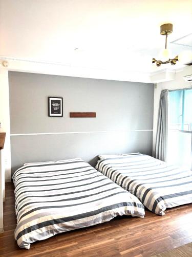 two beds sitting next to each other in a bedroom at Guest House Re-worth Yabacho1 202 in Nagoya