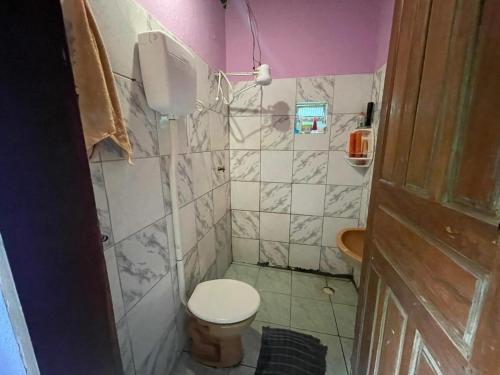 a small bathroom with a toilet and a sink at Casa oblíqua no Vale do Capão in Palmeiras