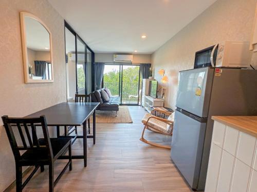 a kitchen and dining room with a table and a refrigerator at The Title Residencies Naiyang F by Mill in Nai Yang Beach
