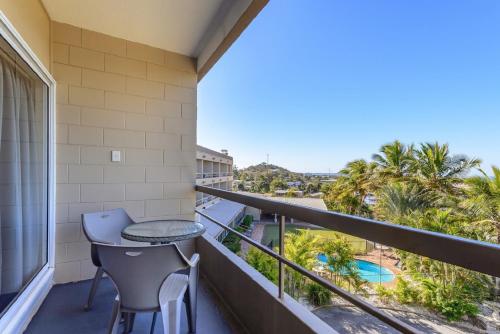 a balcony with a table and chairs and a view at Camelot Motel Australia in Gladstone