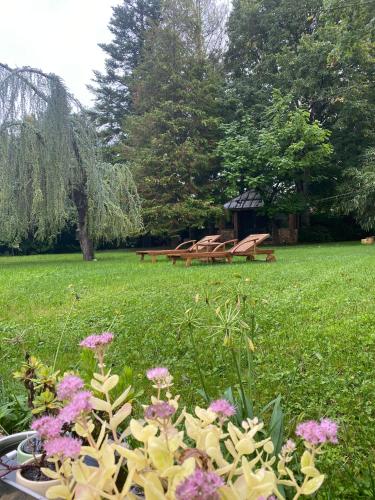 a park with picnic tables and flowers in the grass at LE PRESBYTERE in Chasnay