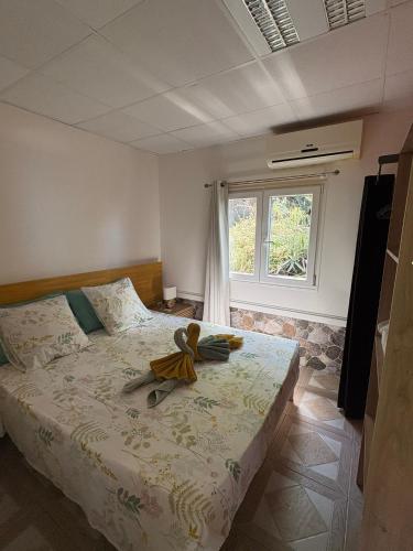 a bedroom with a bed with a teddy bear on it at Habitations Amédée in Bouillante