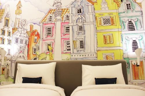 a bedroom with a wall mural of buildings at YELLO Hotel Harmoni in Jakarta