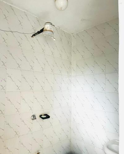 a white tiled bathroom with a shower and a toilet at Zion Homes in Taveta