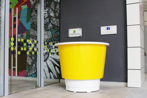 a large yellow trash can in front of a building at YELLO Hotel Harmoni in Jakarta