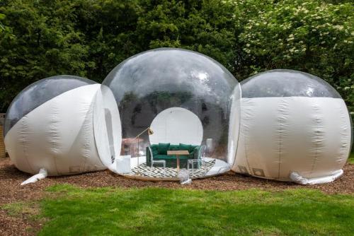 three domes with a green chair in the middle at Grand bubble in Kent