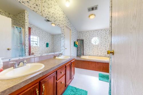 a bathroom with two sinks and two mirrors at Boat Dock! 'Sunshine House' on St. Johns River in Astor
