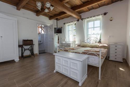 a bedroom with a white bed and a table at Mandulaág Vendégház in Egerszalók