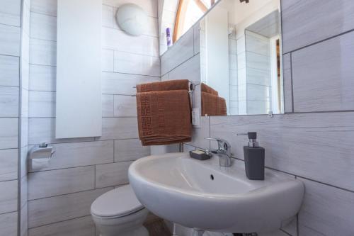 a white bathroom with a sink and a toilet at Mandulaág Vendégház in Egerszalók