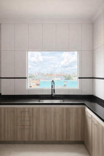 a kitchen with a sink and a window at Apê 401 - Central, Garagem e Ar-Condicionado - 2Q in Governador Valadares