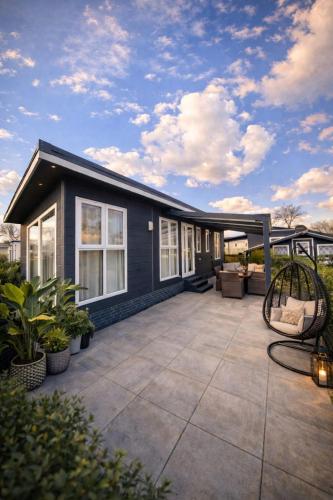 a house with a large patio with a patio at Luxus Chalet im schönen Recratiepark De Veerstal in Rheden