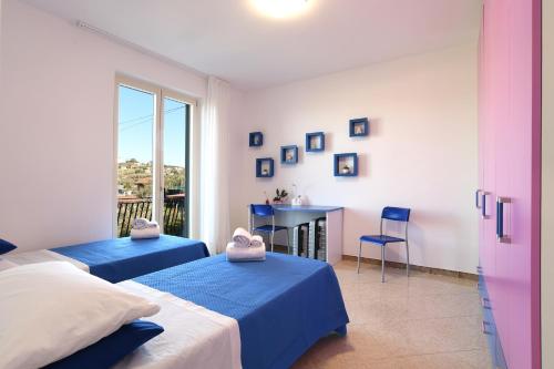 a bedroom with two beds and a table and a window at Casa Saveria in Massa Lubrense