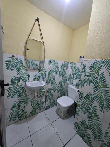 a bathroom with a toilet and a sink and a mirror at Quarto solteiro custo-benefício in São Luís