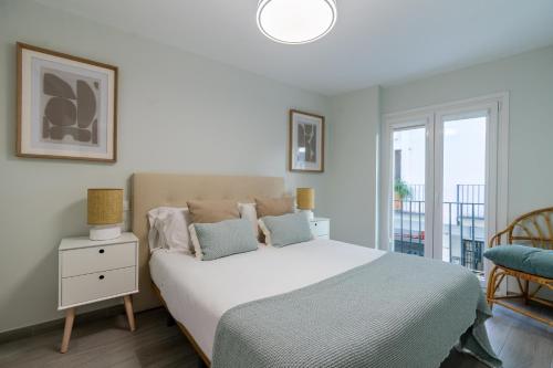 a bedroom with a large bed and a balcony at UNIQUE HOMES LAS SETAS LA CAMPANA in Seville