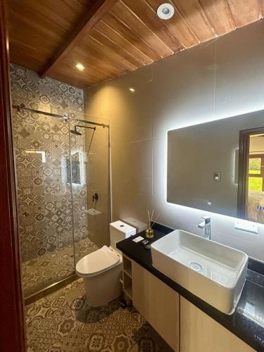 a bathroom with a sink and a toilet and a shower at Casa del abuelo Lodge in Cajamarca