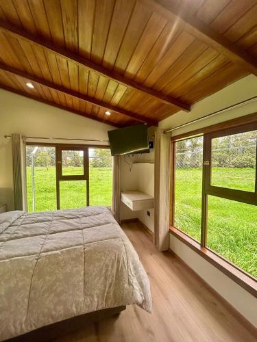 a bedroom with a bed and a large window at Casa del abuelo Lodge in Cajamarca