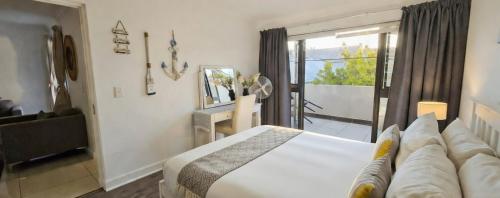 a hotel room with a bed and a balcony at Sandstone - 2 x Bedroom Apartment! in Knysna