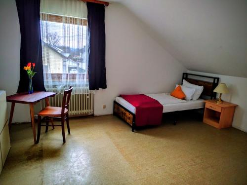 a bedroom with a bed and a table and a window at Haus - Baden-Baden - 8x Zimmer in Sandweier