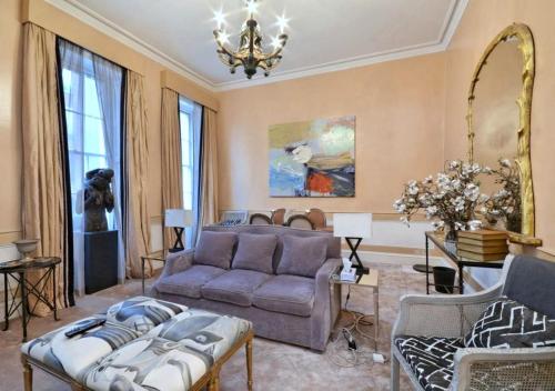 a living room with a couch and a chandelier at Mayfair Green Park Premium Serviced Apartment with 24h Guest Assistance in London
