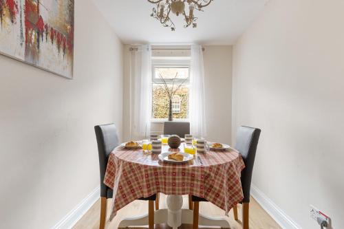 a dining room table with a checked table cloth on it at The Nook - Quaint Victorian Home With Free Parking in York