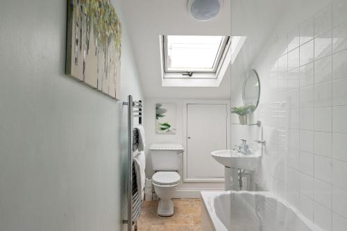 a bathroom with a toilet and a sink and a window at The Nook - Quaint Victorian Home With Free Parking in York