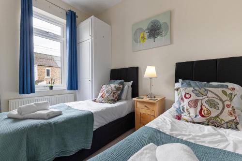 a bedroom with two beds and a window at The Nook - Quaint Victorian Home With Free Parking in York