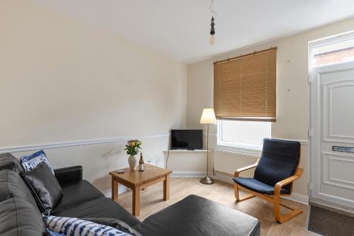 a living room with a couch and a chair at The Nook - Quaint Victorian Home With Free Parking in York