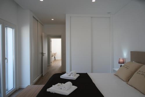 a bedroom with a bed with two towels on it at Refúgio de Ferrel in Ferrel