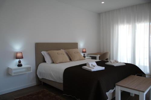 a bedroom with a bed with two towels on it at Refúgio de Ferrel in Ferrel