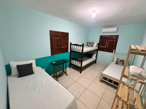 a room with two beds and a desk in it at Beach House Sao Jose in São José da Coroa Grande