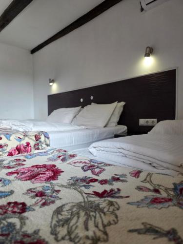 two beds in a hotel room with a floral carpet at Villa Elena in Yanoshi