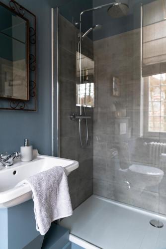 a bathroom with a white sink and a shower at Villa Grand Maur in Spa