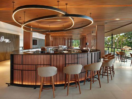 a kitchen with a bar with a bunch of chairs at Royal Tulip Gunung Geulis Resort and Golf in Bogor