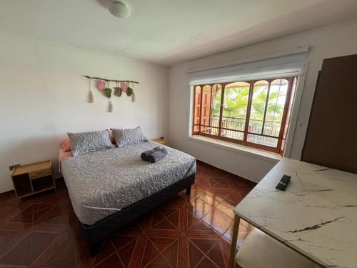 a small bedroom with a bed and a window at Hostal El Ancla in Caldera