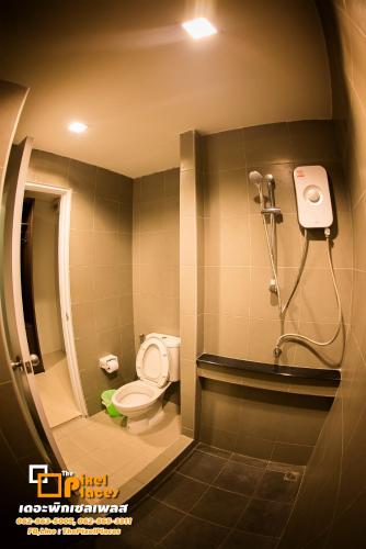 a bathroom with a toilet and a shower at The Pixel Places in Nonthaburi