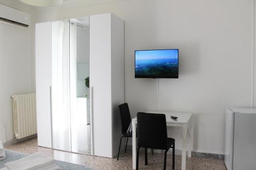 a room with a table and a television on a wall at Felicia in Bisceglie