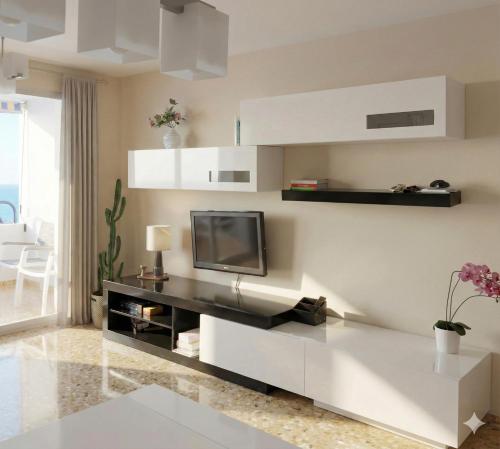 a living room with a tv on a wall at Apartamento en primera línea de la playa a 15 minutos de la Ciudad de Valencia in Valencia