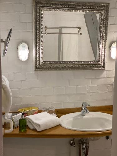 ein Badezimmer mit Waschbecken und Spiegel in der Unterkunft Hotel Grander Mühle in Kuddewörde