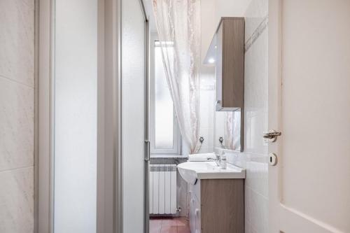 a white bathroom with a sink and a window at Residenza Torre Antica - Nel Cuore di Viterbo in Viterbo