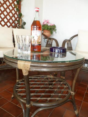 a bottle of alcohol sitting on a glass table at Hotel Panorama di Sicilia in Castelmola